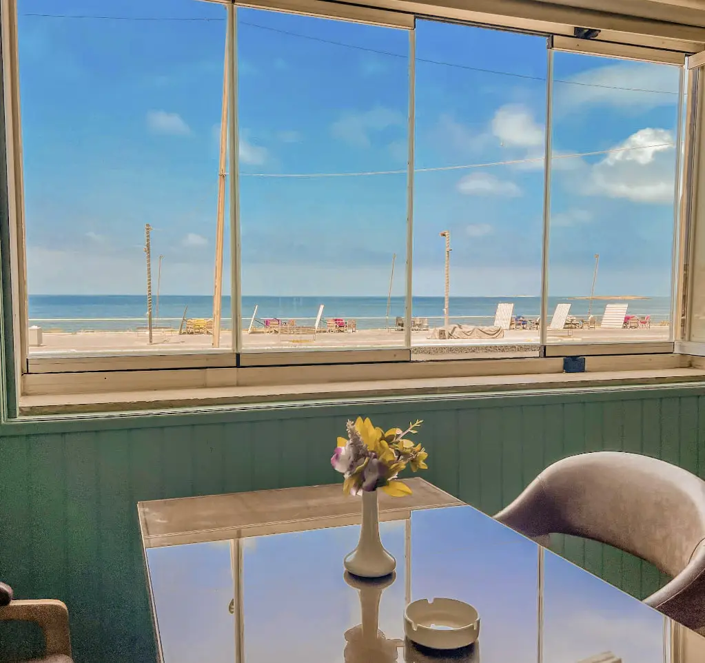 A table set by the window at The Sailor Woman, looking out over the beach and the Mediterranean at El Mina